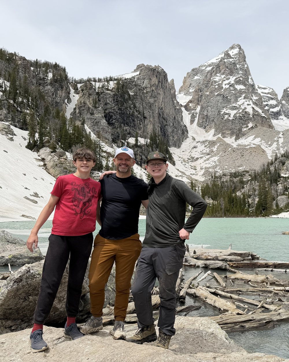 Dustin with his sons Colten and Cash on a hike below snow-covered peaks